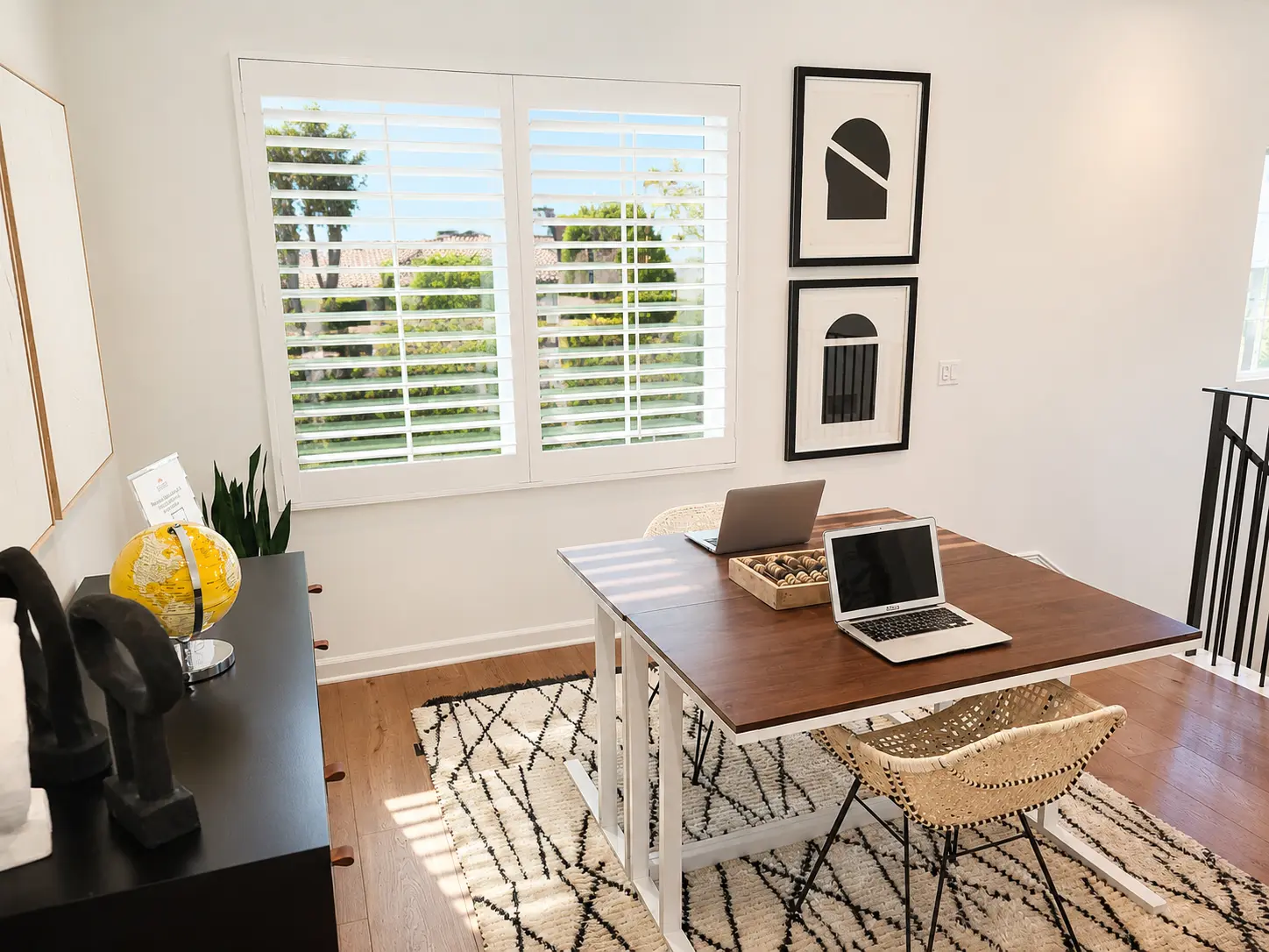 White plantation shutters above a built-in desk in a small home office