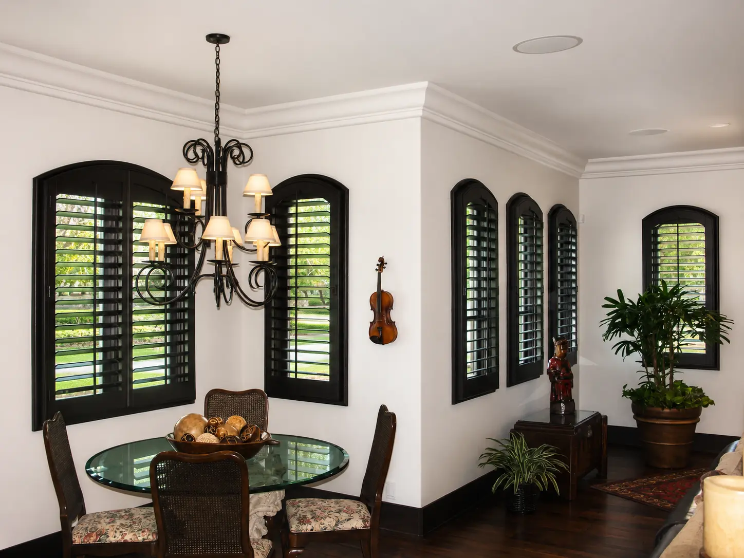 Black-painted arched plantation shutters in a formal dining room