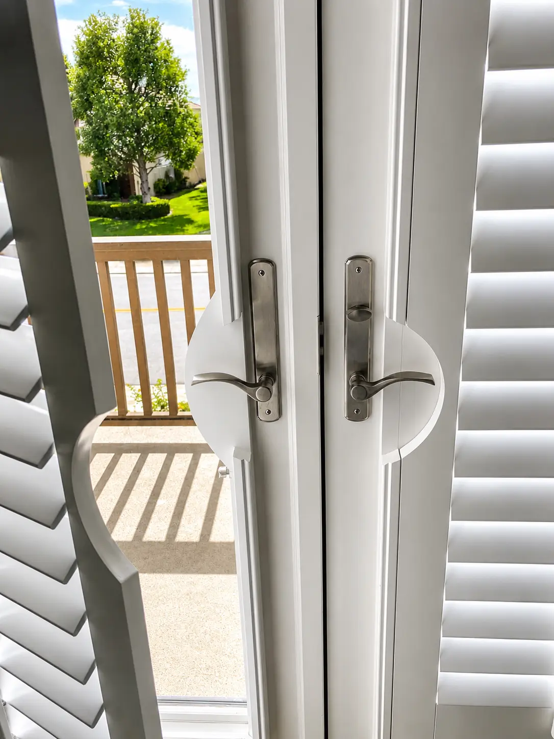 Close-up of plantation shutter door handles and louvers on a French door