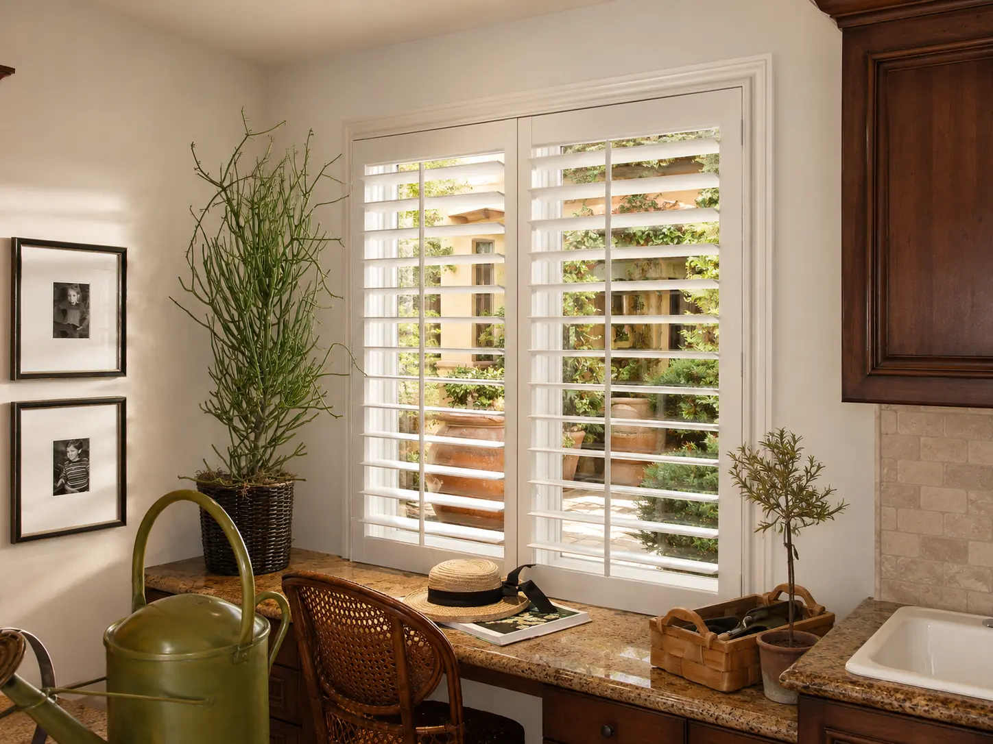 White plantation shutters above a desk overlooking a courtyard