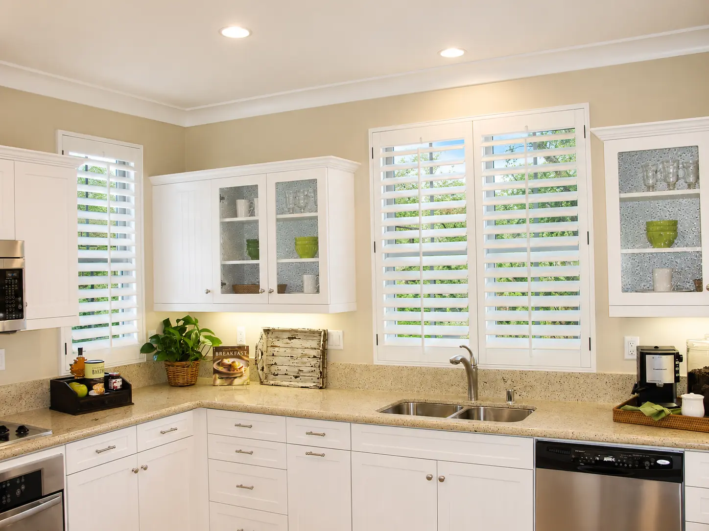 White plantation shutters above a kitchen sink and pantry window