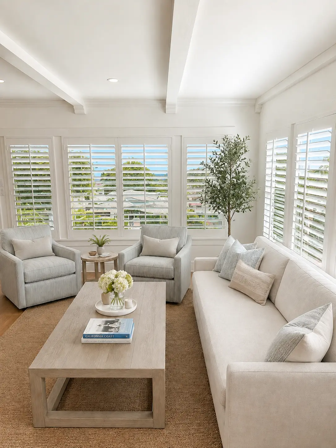 White plantation shutters wrapping a coastal-style sitting room