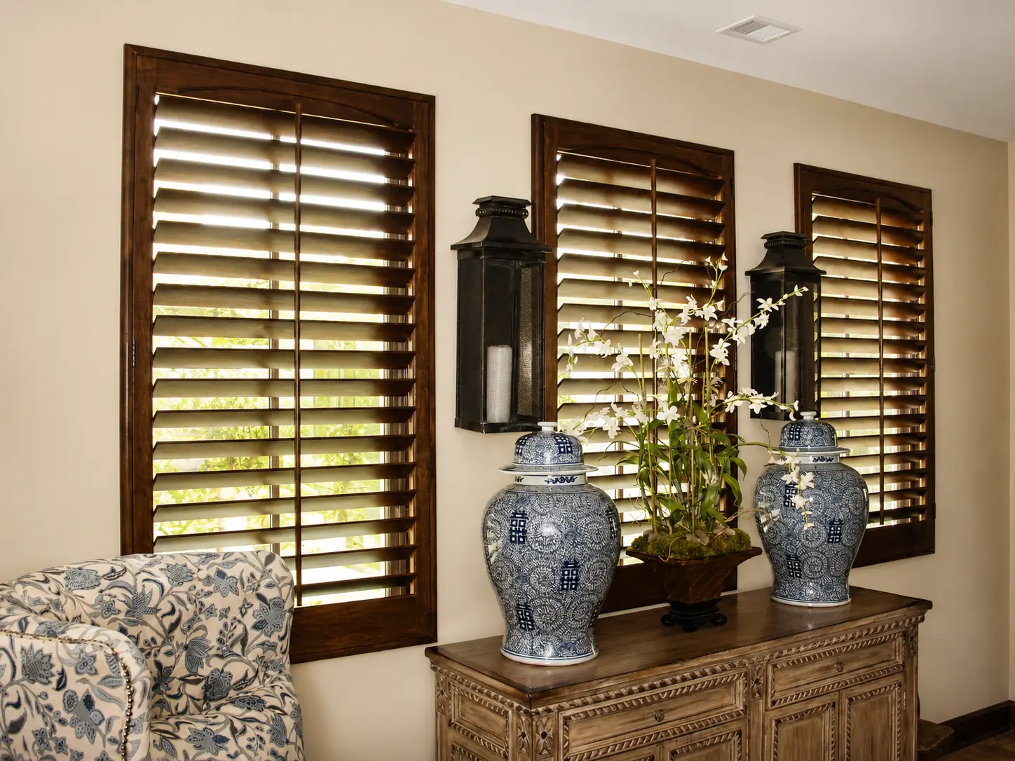 Dark stained wood plantation shutters in a traditional sitting room