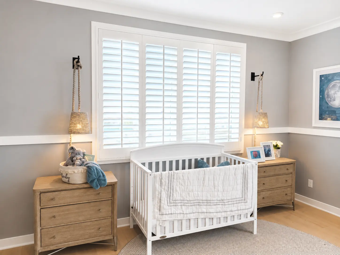 White plantation shutters in a baby nursery with crib