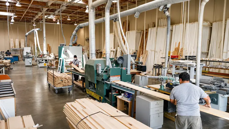 Workers milling shutter components on the Golden West factory floor in Lake Forest, CA